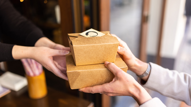 Takeout boxes being passed off