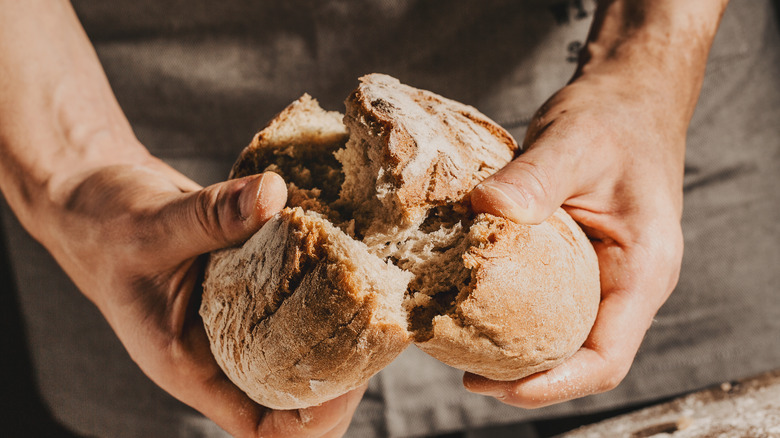 Person breaking bread