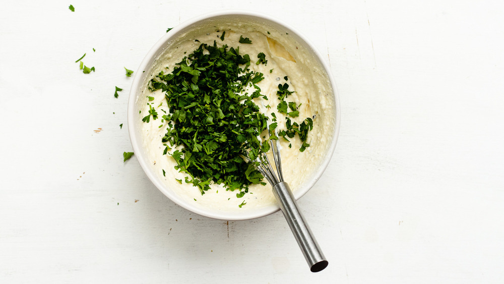 Chopped parsley being mixed into ricotta