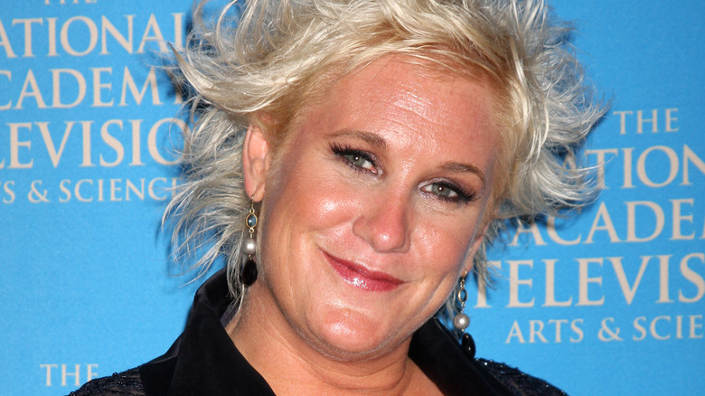 Anne Burrell smiling and tilting her head to the side