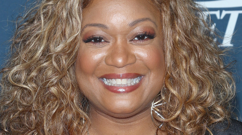 Sunny Anderson with hair down and wide smile