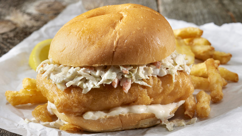 Fish sandwich with fries on table