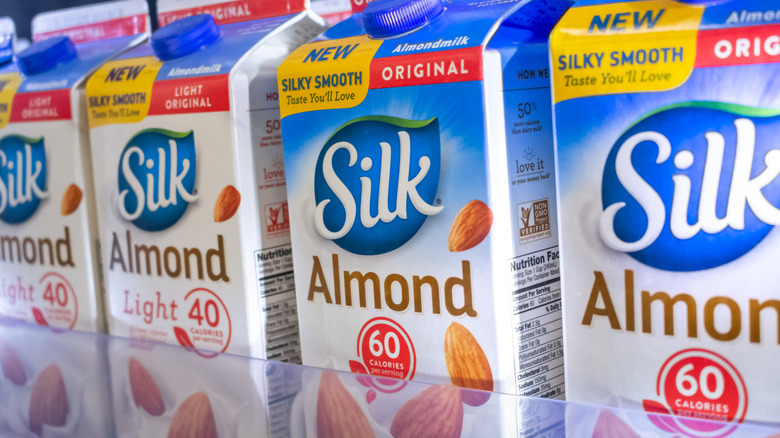 A shelf of Silk Almond milk cartons