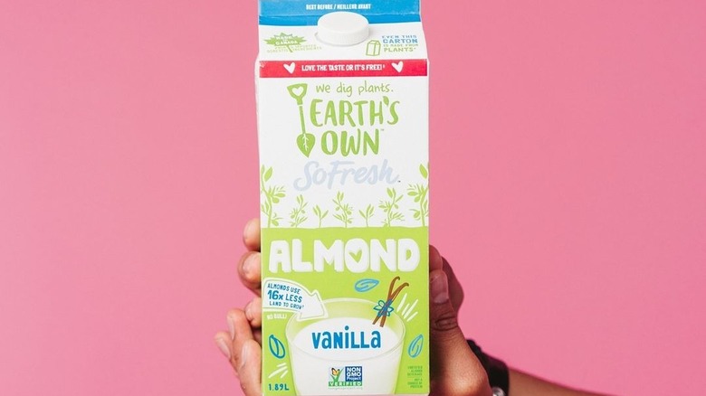 Hands holding a box of Earth's Own almond milk