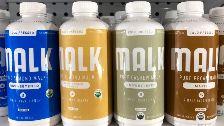 A shelf with bottles of Malk almond milk