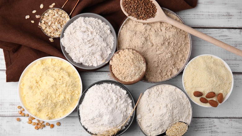 Bowls of flour with a wooden spoon