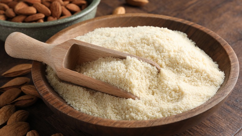 Almond flour in a wooden bowl with a wooden scoop