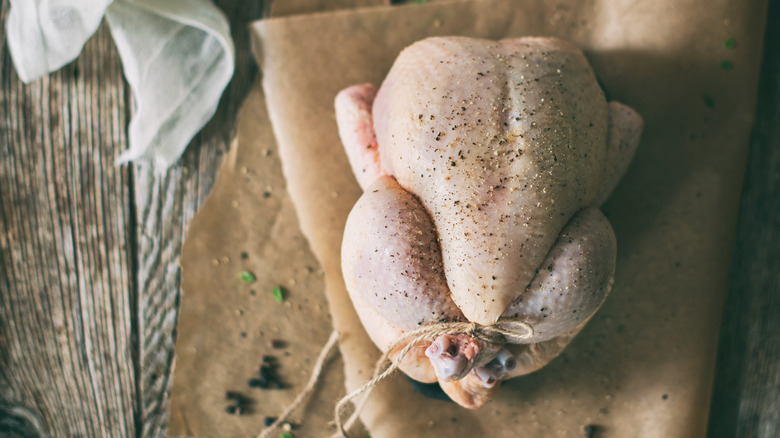 whole raw chicken on baking parchment