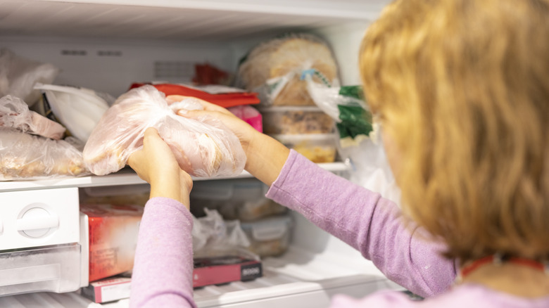 women putting meat in freezer