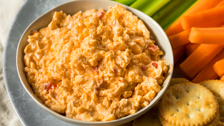 bowl of pimento cheese with crackers celery carrots