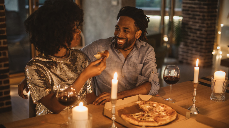 Couple shares pizza by candlelight