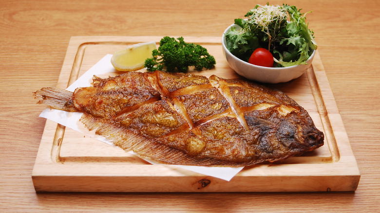 Cooked flounder on wooden board