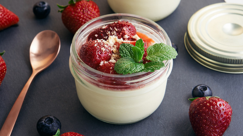 Ramekin of sous vide cheesecake with strawberries and fresh mint leaves