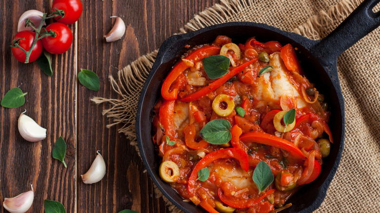 stewed tilapia with peppers and olives in cast iron skillet