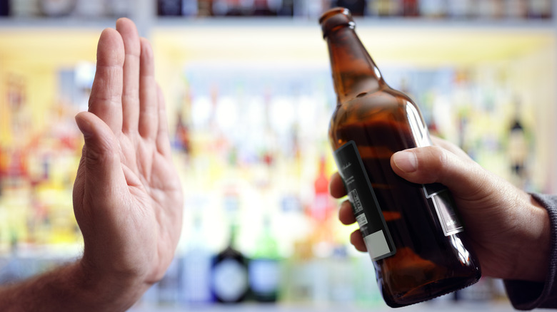 Hand rejecting dark beer bottle