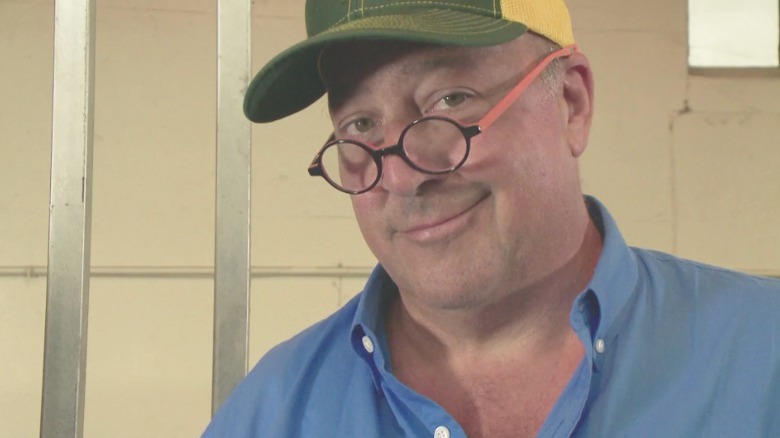 Andrew Zimmern wearing glasses, smiling