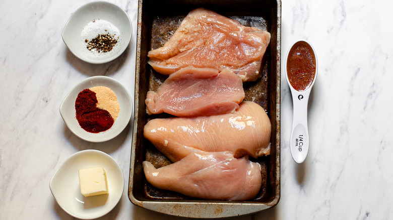 chicken breasts prepared with spices and butter for blackened chicken