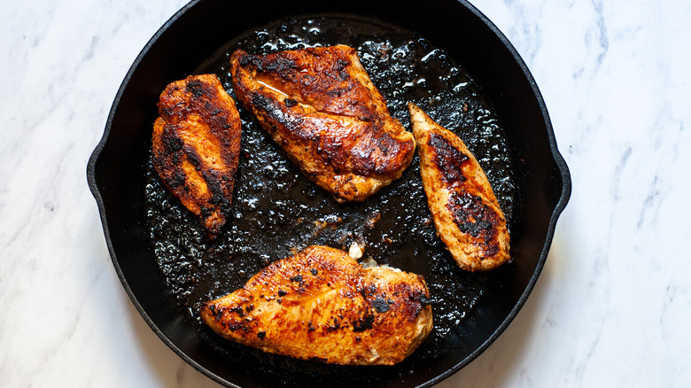 Cooked chicken breasts on a skillet.