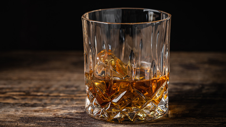 glass of bourbon on wood table