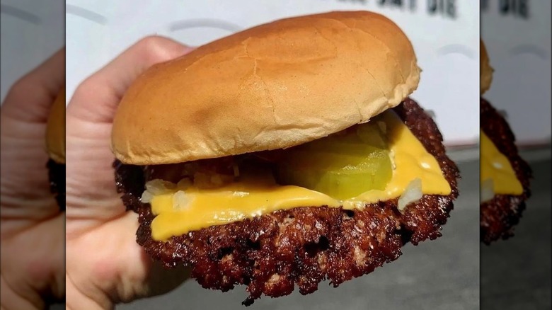 Burger in front of white building