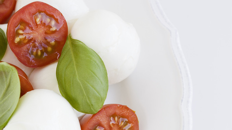 Pearls of fresh mozzarella with tomatoes and bazil