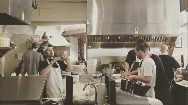 Line cook throwing pizza dough at Jackson's