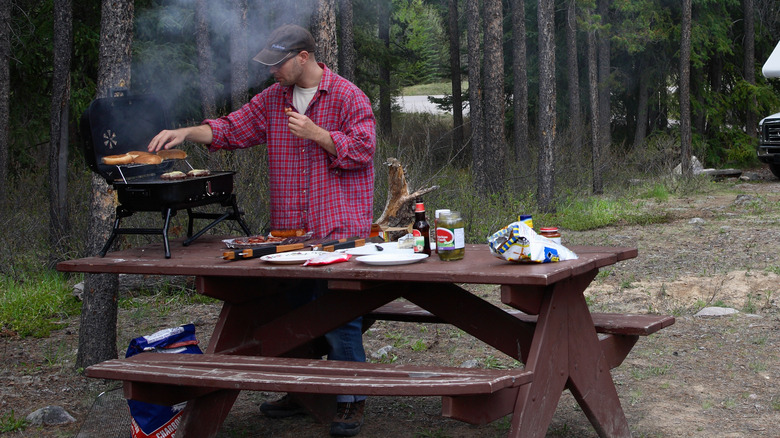 man grilling at campsite