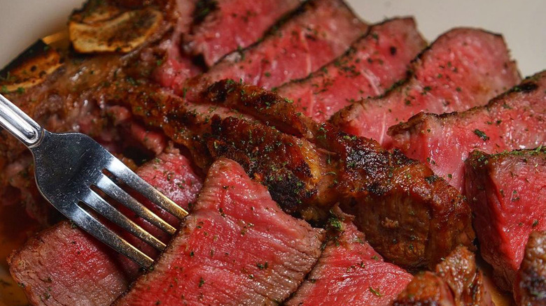 Sliced Morton's steak with fork