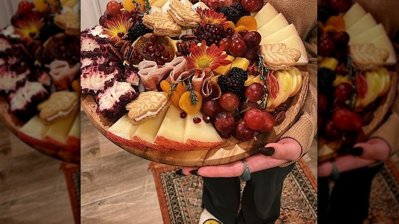 woman holding charcuterie board