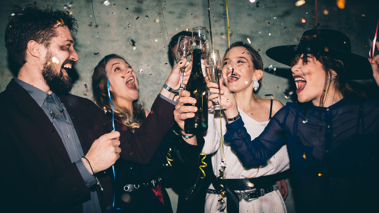 group of people toasting with glasses of sparking wine