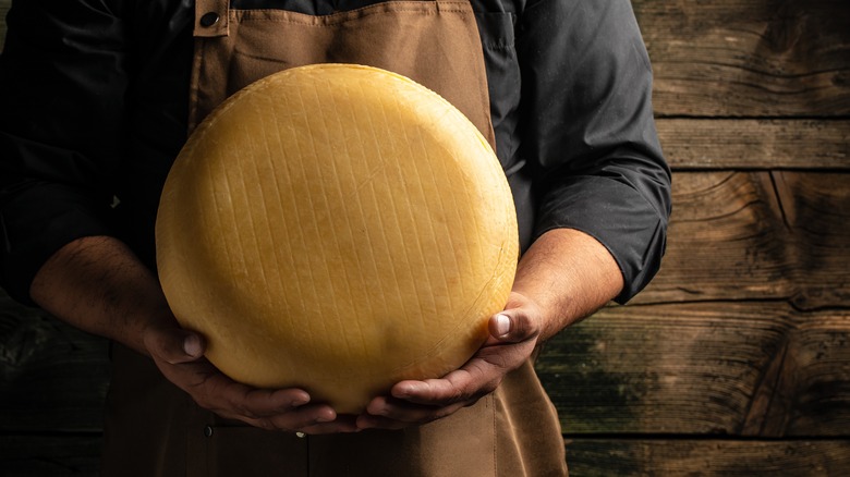 cheese monger holding wheel 