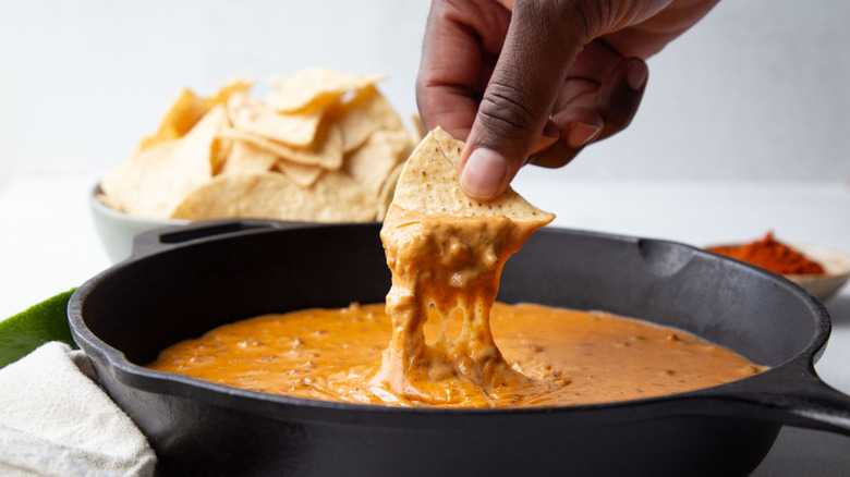 hand dunking tortilla chip