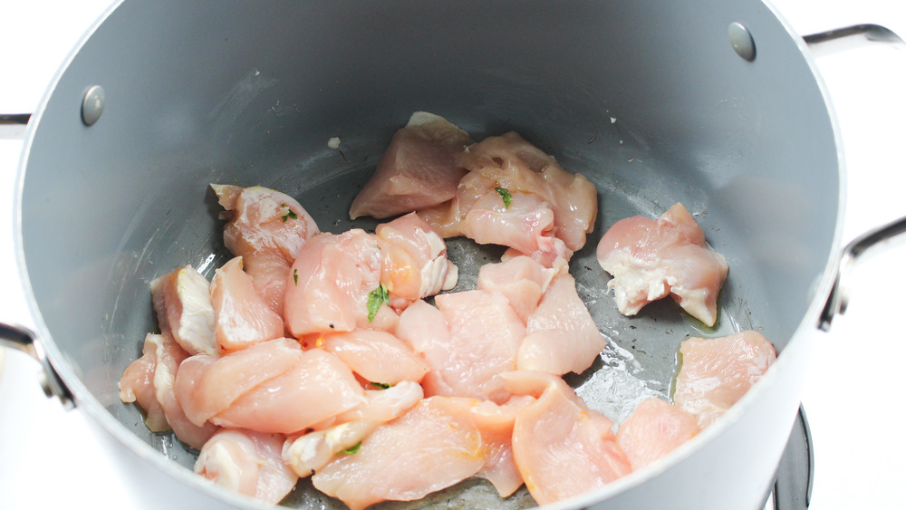 raw chicken in pot with oil