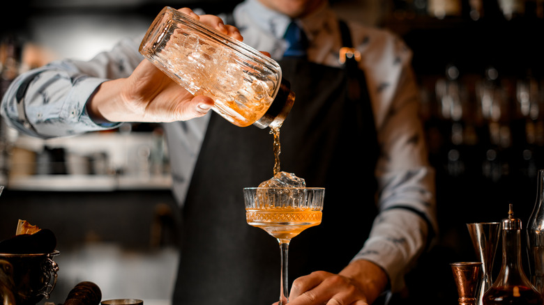 Bartender pouring cocktail from shaker