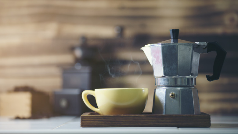 Coffee percolator next to yellow mug