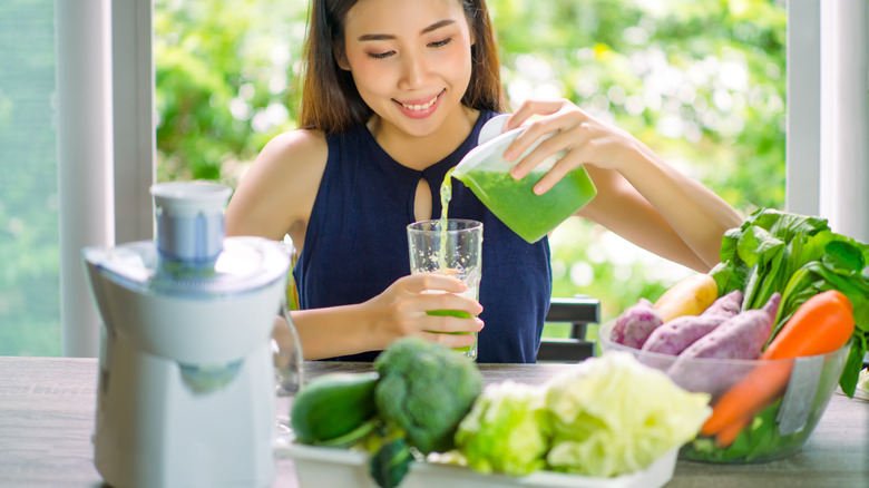 Woman pouring juice and juicer