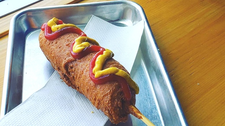 Corn dog with condiments