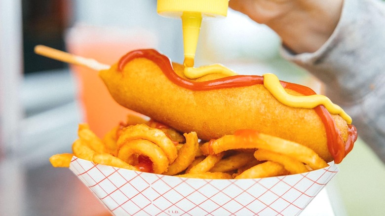 Corn dog with condiments