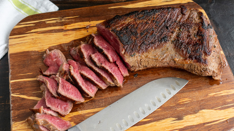 tri-tip steak on wooden cutting board