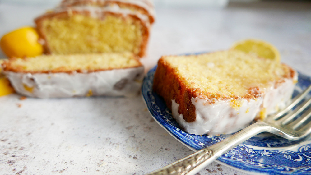 sliced iced lemon pound cake on a plate with a fork