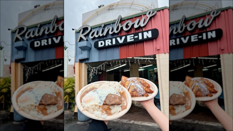Hands holding loco moco plate in front of Rainbow Drive-In sign