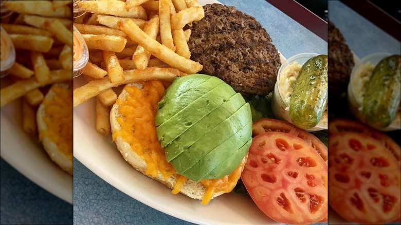 Burger with avocado and fries 