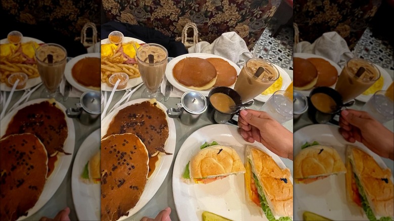 Pancakes, coffee, and sandwich on a table