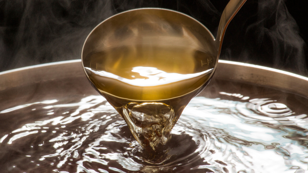 Ladle pouring dashi in a pot