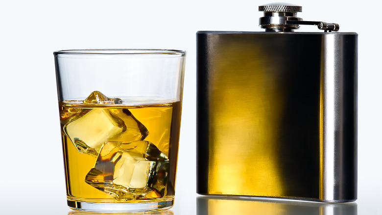 flask and whiskey in glass