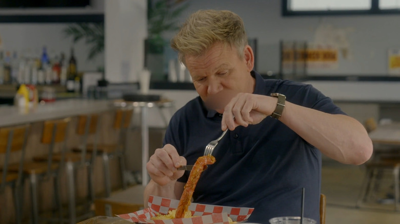 Gordon Ramsay holds up shriveled hot dog with fork