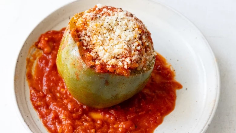 A stuffed pepper with tomato sauce