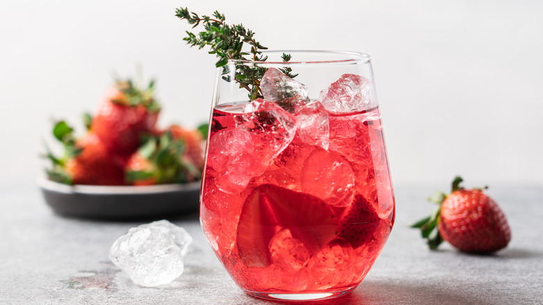 Red cocktail with thyme sprig