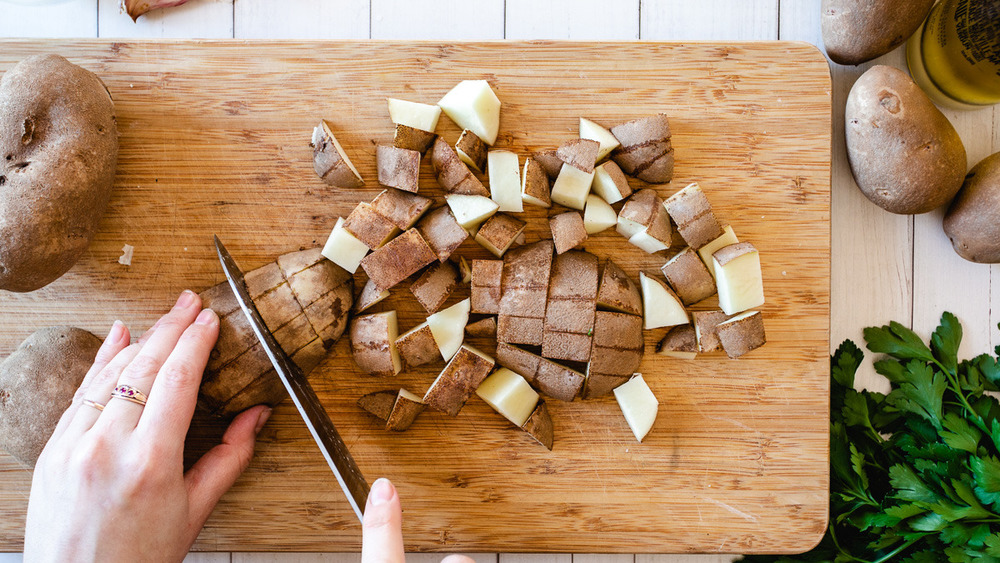 woman's hand chopping potatoes