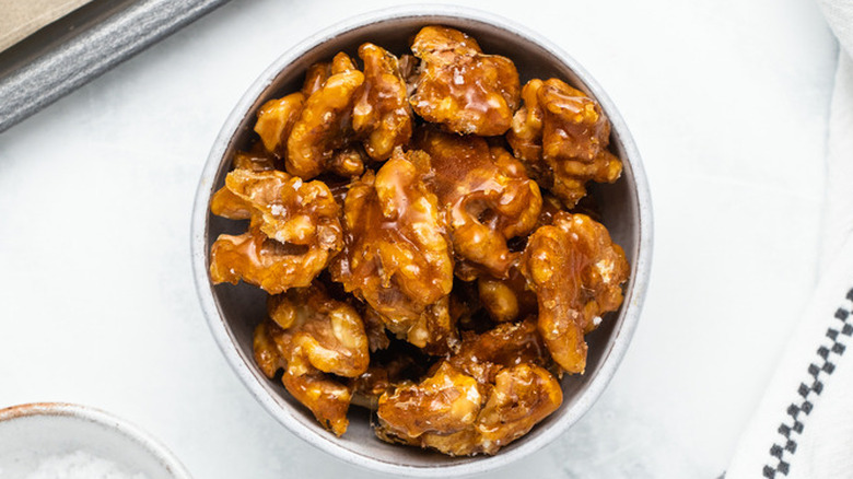 Large candied walnut pieces in a round bowl. 